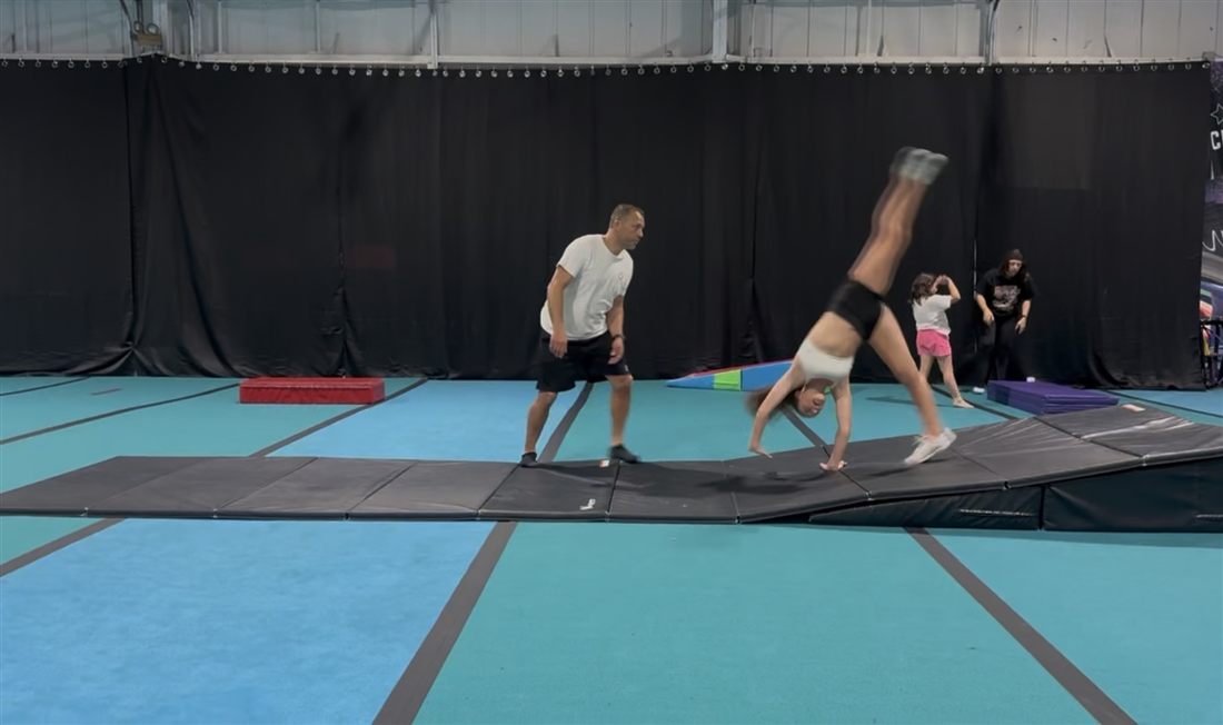 Coach spotting an athlete's handstand