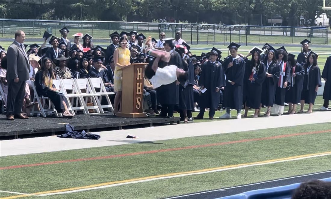 Athlete throwing a backflip at graduation